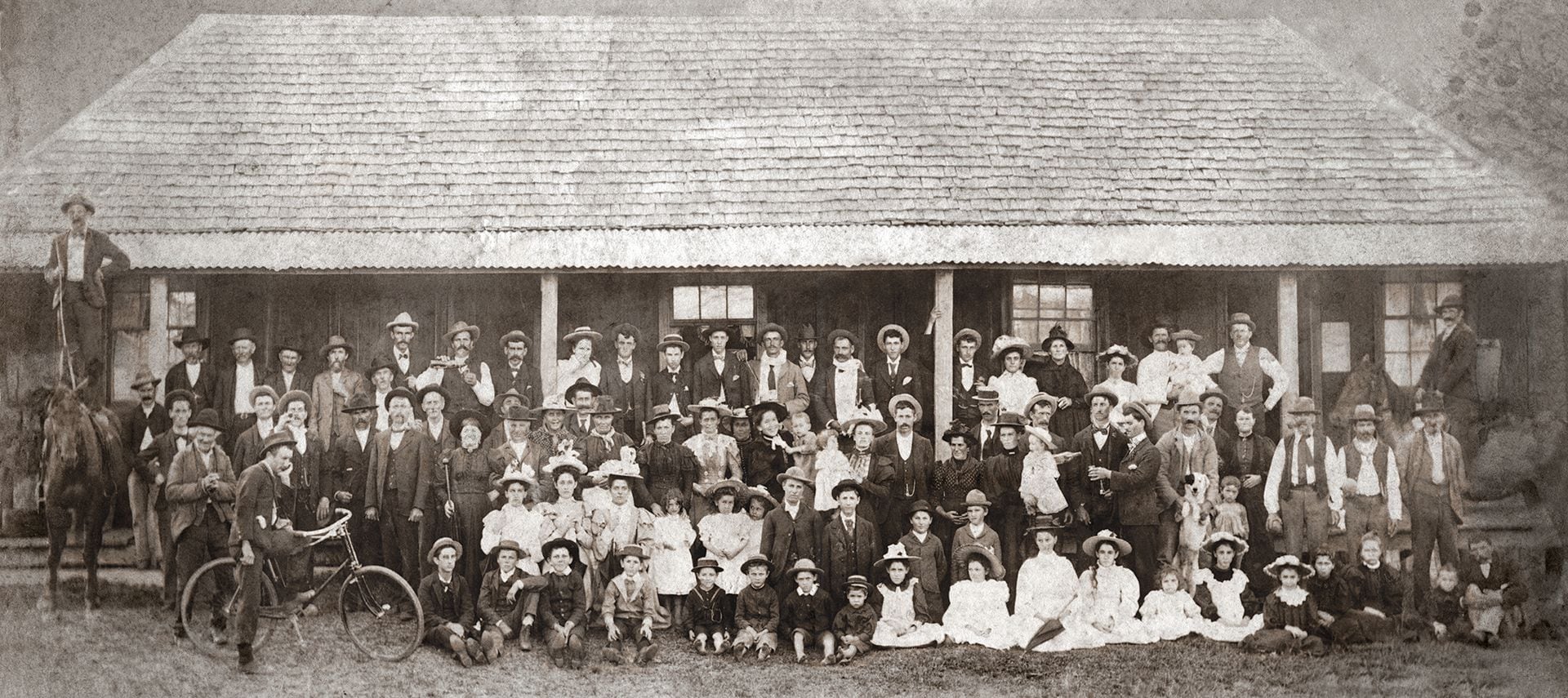 The pioneer community posed outside the original settlement hall, c. early 1900s